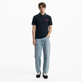 A male model is wearing jeans paired with the Smith's 1906 MPO01 Navy Polo.