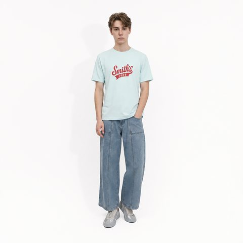 A male model is wearing a pair of jeans paired with the Smith's 1906 MTE02 Blue T-Shirt.