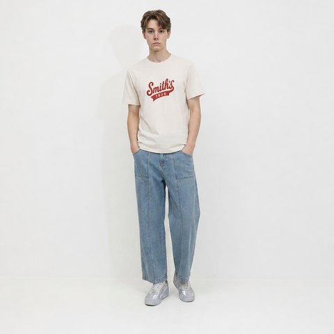 A male model is wearing a pair of jeans paired with the Smith's 1906 MTE02 Off White T-Shirt.