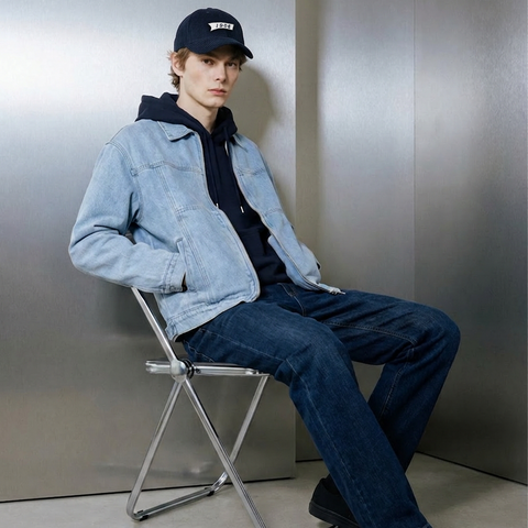 A male model wearing Smith's 1906 clothing is sitting on a chair.