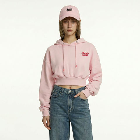 A female model is wearing a hoodie paired with the Smith's 1906 UCP02 Pink Cap.