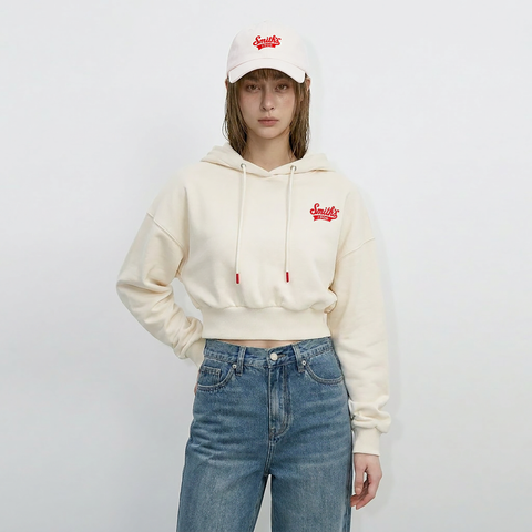A female model is wearing a hoodie paired with the Smith's 1906 UCP02 White Cap.