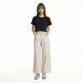 A female model is wearing a pair of pants paired with the Smith's 1906 WTE01 Black T-shirt.