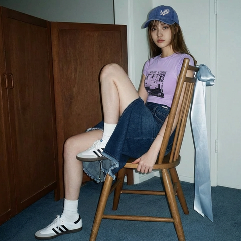 A female model wearing Smith's 1906 clothing is sitting on a chair.