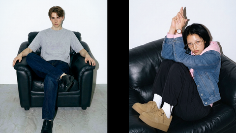 One male model and one female model wearing Smith's 1906 clothing are sitting on a sofa.