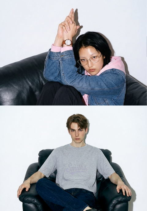 One male model and one female model wearing Smith's 1906 clothing are sitting on a sofa.